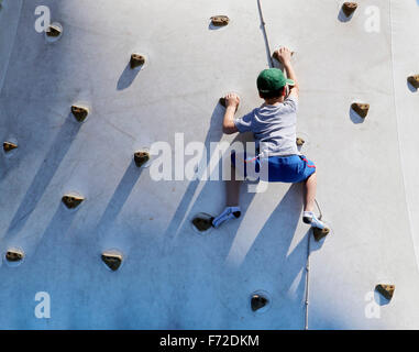 Kinder lernt, während eine lokale Jugend Sportmesse an einer Kletterwand klettern. Stockfoto
