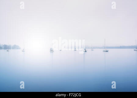 Segelyacht im Nebel am Lake Windermere im Lake District getönt blau Stockfoto