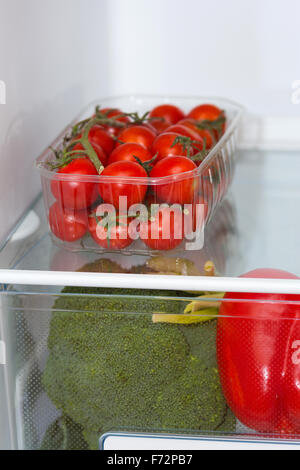 Frische Lebensmittel, Obst und Gemüse in den Regalen in den Kühlschrank stellen Stockfoto