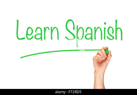 Die Hand einer Frau das Wort Spanisch lernen auf einem klaren Bildschirm zu schreiben. Stockfoto