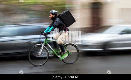 Berlin, Deutschland. 18. November 2015. Fahrradkurier für den Lieferservice "Deliveroo", Roberto Urso (29), auf dem Weg zu einer Kundenbestellung in Berlin, Deutschland, 18. November 2015 liefern. Foto: GREGOR FISCHER/DPA/Alamy Live-Nachrichten Stockfoto