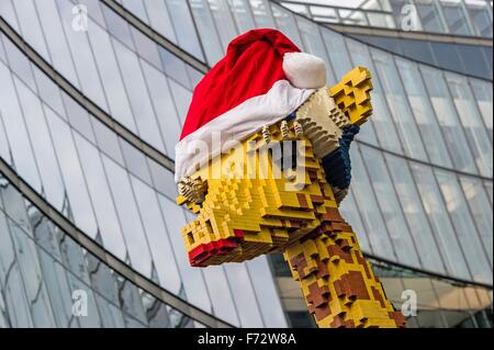 Berlin, Deutschland. 24. November 2015. Eine Giraffe aus Legosteinen trägt eine rote Weihnachtsmütze vor Legoland am Potsdamer Platz in Berlin, Deutschland, 24. November 2015 gebaut. Foto: PAUL ZINKEN/DPA/Alamy Live-Nachrichten Stockfoto