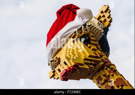 Berlin, Deutschland. 24. November 2015. Eine Giraffe aus Legosteinen trägt eine rote Weihnachtsmütze vor Legoland am Potsdamer Platz in Berlin, Deutschland, 24. November 2015 gebaut. Foto: PAUL ZINKEN/DPA/Alamy Live-Nachrichten Stockfoto