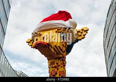 Berlin, Deutschland. 24. November 2015. Eine Giraffe aus Legosteinen trägt eine rote Weihnachtsmütze vor Legoland am Potsdamer Platz in Berlin, Deutschland, 24. November 2015 gebaut. Foto: PAUL ZINKEN/DPA/Alamy Live-Nachrichten Stockfoto