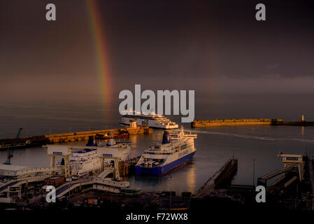 Einen leuchtenden Regenbogen am Himmel über Dover mit P & O Fähre in der Hafeneinfahrt. Stockfoto