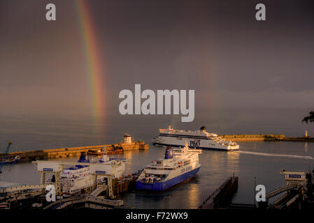 Einen leuchtenden Regenbogen am Himmel über Dover mit P & O Fähre in der Hafeneinfahrt. Stockfoto