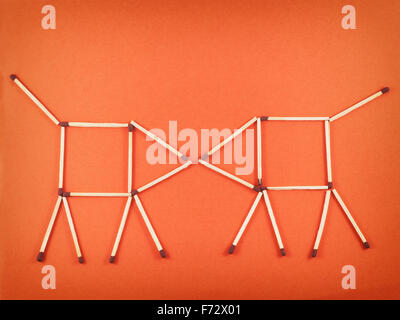 Zwei Schweine spielen auf orangem Hintergrund. Lustiges Bild. Stockfoto