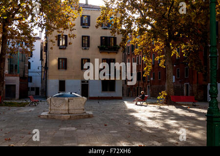 Campo San Agnese in Sestiere di Dorsoduro in Venedig. Eine Frau eine Frau, die im Herbst lesen. Stockfoto