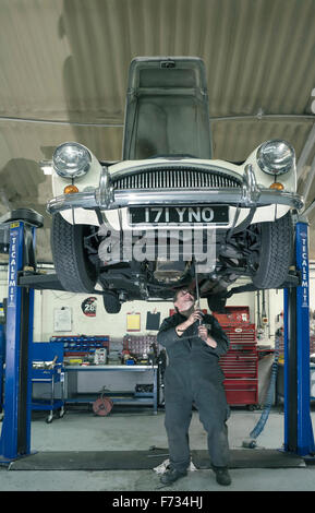 Austin Healey 3000 auf einer Hebebühne in einer Oldtimer-Werkstatt repariert wird Stockfoto
