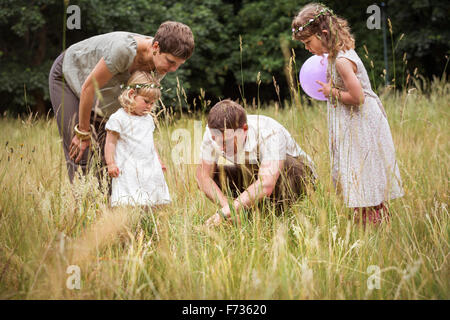 Familie mit zwei Kindern auf einer Wiese spielen. Stockfoto