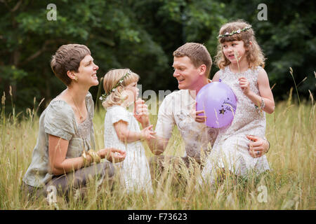 Familie mit zwei Kindern auf einer Wiese spielen. Stockfoto