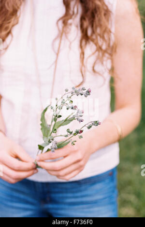 Nahaufnahme einer Frau mit einer wilden Blume. Stockfoto