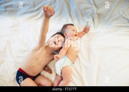 Zwei Kinder, ein Bruder und Baby Schwester liegend zusammen zu spielen. Stockfoto