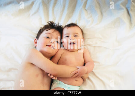 Zwei Kinder, ein Bruder und Baby Schwester liegend zusammen zu spielen. Stockfoto