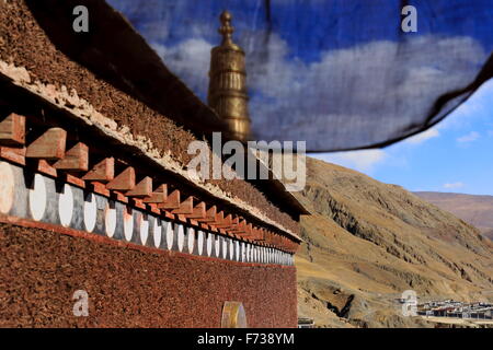 Vergoldete Dhvaja-Siegesbanner auf Dachterrasse-blau Stoffvorhang. Aus Gründen der 1073 AD-Khon Konchog Gyalpo gebaut Sakya m Schrein Stockfoto