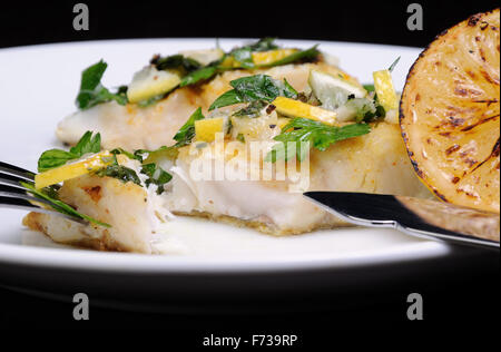 Stück gebackener Fisch Barsch mit Kräutern und Zitronenscheiben Stockfoto