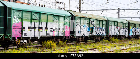Eine Reihe von Zug Güterwaggons Website mit Graffiti auf sie verlassen. Stockfoto