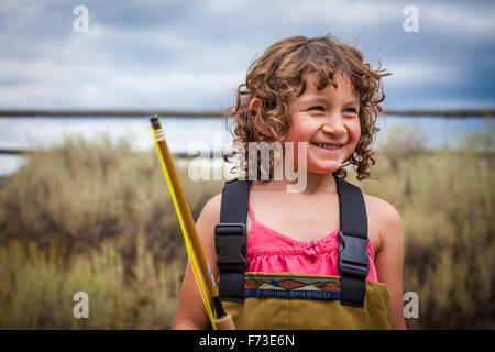 Ein junges Mädchen lächelt während der Vorbereitungen zum Fliegenfischen in Idaho. Stockfoto