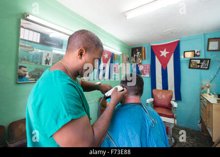 Ein Mann bekommt einen Haarschnitt in einem Friseursalon in Havanna, Kuba. Stockfoto