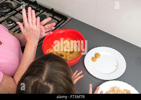 Mutter und Tochter kneten Marzipan für machen Panellets in der Küche. Stockfoto