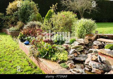 Wasserfall und Garten gemischten krautige erhöhte Beet im Herbst Stockfoto