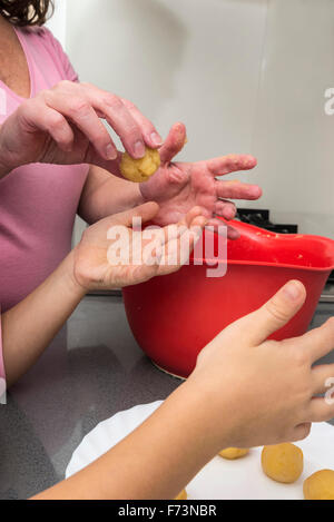 Mutter und Tochter kneten Marzipan für machen Panellets in der Küche. Stockfoto