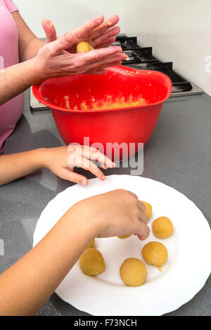 Mutter und Tochter kneten Marzipan für machen Panellets in der Küche. Stockfoto