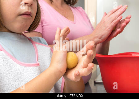 Mutter und Tochter kneten Marzipan für machen Panellets in der Küche. Stockfoto