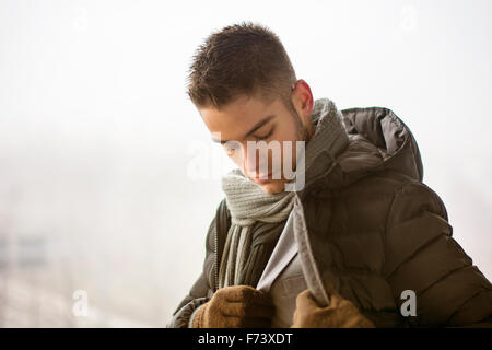 Ansicht von gut aussehenden jungen Mann im Freien im Winter trägt Schal, Profil suchen, denken Stockfoto