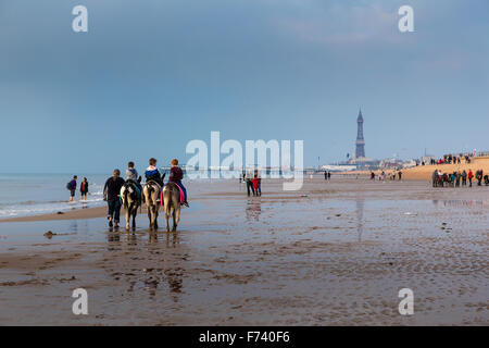 Eselreiten am Strand von Blackpool mit der North Pier und den berühmten Turm in der Ferne Stockfoto