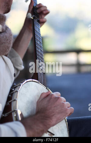 Banjo-Spieler üben einige Songs im Morgenlicht, in einer ländlichen Umgebung. Stockfoto