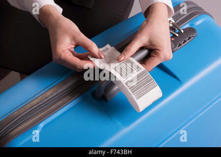 Fluggesellschaft einchecken Anhaftung an einen Koffer-Gepäck-Umbau Stockfoto