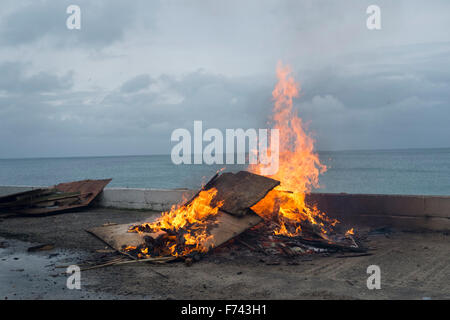 Ein Lagerfeuer an der Seite des Gylly Beach Cafe, Falmouth Cornwall wie sie Holz und andere Abfälle verbrennen Stockfoto