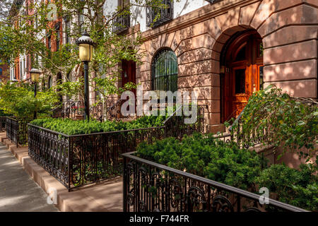 Reihe von Stadthäusern und ihre schöne Vorgärten und Laternen. Am Nachmittag leichte in Chelsea, Manhattan, New York City. Stockfoto