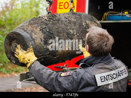 Ronald Weiler von der Bombe Entsorgung Team lädt eine entschärfte Blindgänger-Shell aus dem zweiten Weltkrieg in ein Fahrzeug in Hamburg, Deutschland, 25. November 2015. Rund 4000 Bewohner wurden aus ihren Häusern vor der Entsorgung einer 500-Kilogramm-WWII-Bombe am Morgen des 25 November evakuiert. Foto: DANIEL BOCKWOLDT/dpa Stockfoto