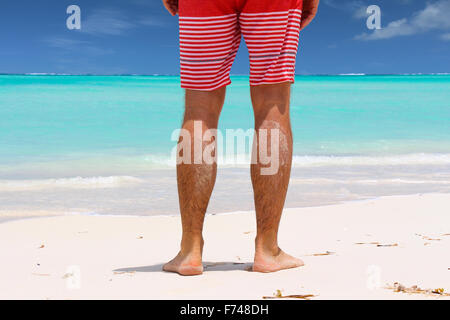 Junger Mann stehen am Strand und das Karibische Meer anzeigen Stockfoto