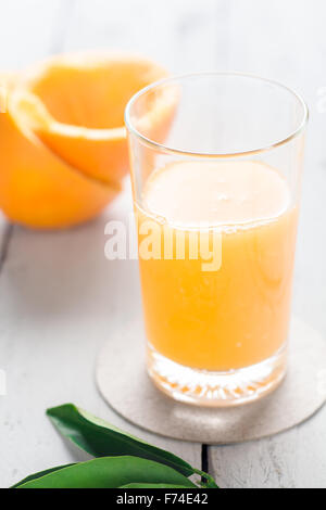 Orangensaft in ein Glas auf weißem Holz Stockfoto