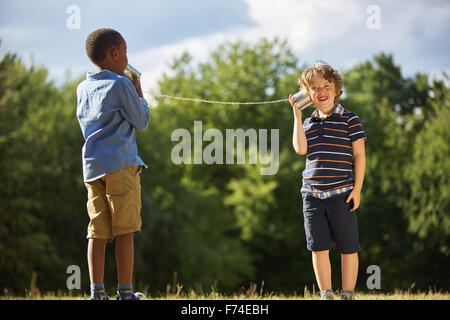 Zwei Jungen spielen mit Blechdose Telefon spielen in der Natur Stockfoto