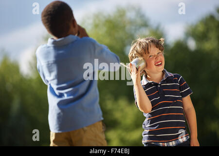 Zwei Jungs spielen mit einem Telefon im Sommer Stockfoto