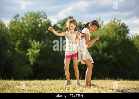 Zwei Mädels unter der Sonne tanzen im Sommer im park Stockfoto