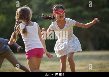 Glückliche Kinder spielen blindekuh im Sommer bei einer Geburtstagsparty Stockfoto