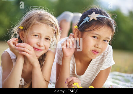 Zwei glückliche Mädchen mit Blumen auf ihre Haare im Sommer Stockfoto