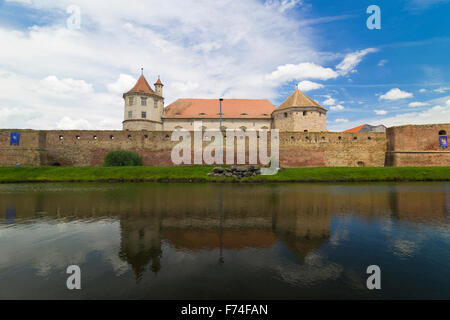 Mittelalterliche Mauern rund um ein altes Schloss und seine Spiegelung im Wasser, Fagaras, Siebenbürgen, Rumänien Stockfoto