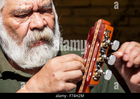 Gitarrenbauer Sistos Pasaye Saiten eines seiner Produkte vor einem Geschäft in Paracho, Michoacan, Mexiko. Stockfoto