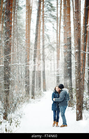 Junges Paar umarmt im Winterwald. Winterurlaub. Wochenendausflug. Platz für Text. Natürliche Farben, selektiven Fokus. Stockfoto