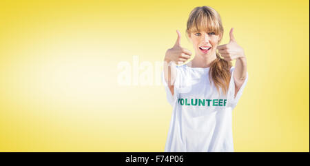 Zusammengesetztes Bild der natürliche Blondine trägt eine Freiwilligenarbeit-t-Shirt Daumen aufgeben Stockfoto