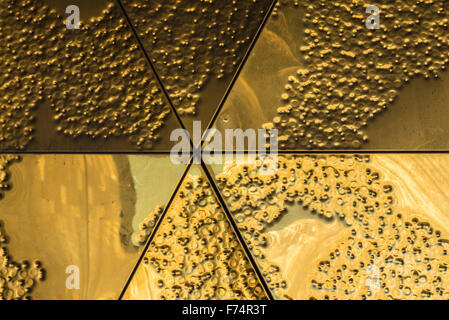 Zusammenfassung Hintergrund auf Gold Metall durch Dreiecke und mehrere Reflexionen und Kreise gebildet Stockfoto