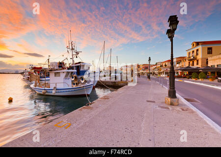 Blick auf die Promenade mit Cafés, Bars und Restaurants und Angelboote/Fischerboote im Hafen von Aegina Insel, Griechenland Stockfoto