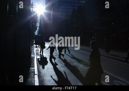 Blaue Schatten und Silhouetten von unkenntlich Menschen hinunter 34th Street in New York City bei Sonnenaufgang Stockfoto