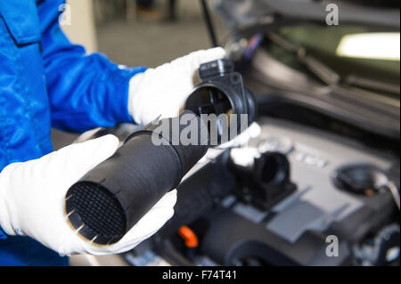 HANDOUT - zeigt ein undatiertes Handout Bild zur Verfügung gestellt von deutschen Automobilhersteller Volkswagen (VW) Angestellter hält eine Blume Haarglätter (L) für 1,6-Liter-Diesel-Motoren vom Typ EA 189 neben eine Air-Flow-Meter. Laut VW der Fluss Haarglätter verbessert die Luftansaugung und Ergebnisverbesserung in effizientere Verbrennung von Kraftstoff, die letztendlich hilft die Auspuff-Ausgabe im Einklang mit den Abgasnormen. Foto: VOLKSWAGEN/Dpa (Achtung Redaktion: für redaktionelle Verwendung nur im Zusammenhang mit aktueller Berichterstattung / Kredit-obligatorisch: Foto: Volkswagen/Dpa) - NO-Draht-SERVICE - Stockfoto